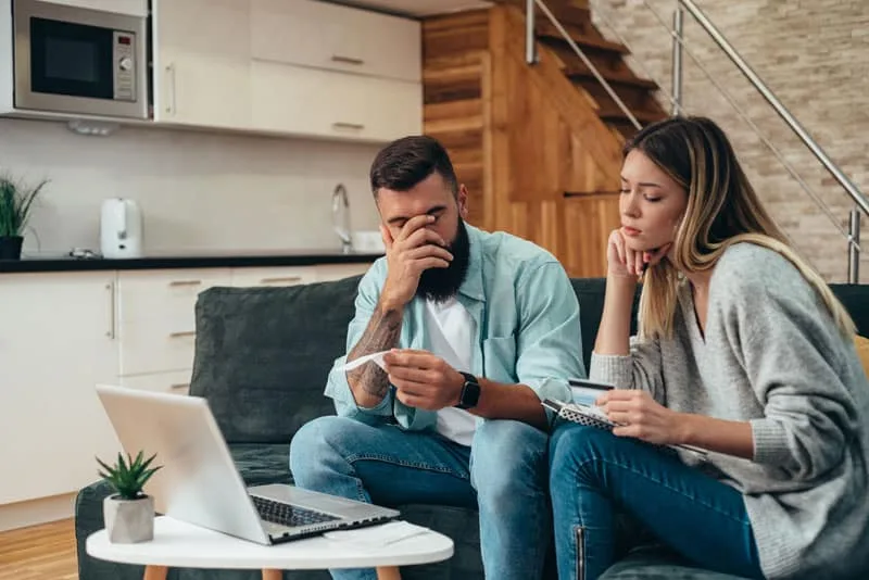 Illustrative couple reviewing finances on a laptop